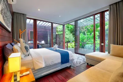 a bedroom with a bed and a large window at Beach Axis Villa, Seminyak in Seminyak