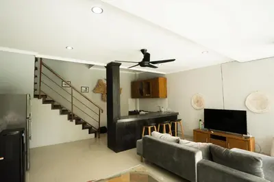 a living room with a couch and a ceiling fan at The Catur Villa Seminyak in Seminyak