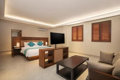 a bedroom with a bed and a tv and a couch at Anja Jimbaran in Jimbaran