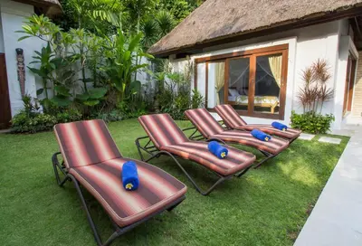 a group of brown chairs sitting on the grass at Villa Kamboja Senior in Legian