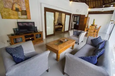 a living room with two couches and a coffee table at Villa Kamboja Senior in Legian