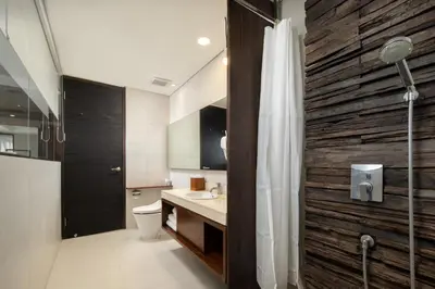 a bathroom with a toilet and a sink and a shower at The Akmani Legian in Legian