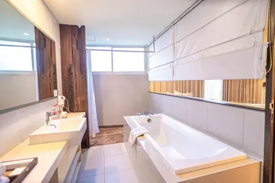 a bathroom with a tub and a sink at The Akmani Legian in Legian