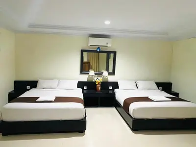 a bedroom with two beds and a mirror at Dedy Beach Inn in Kuta