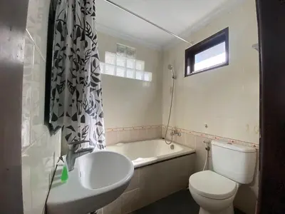 a bathroom with a toilet and a sink and a tub at Dedy Beach Inn in Kuta
