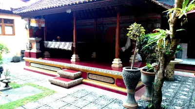 a porch of a house with potted plants at Agus Beach Inn in Kuta