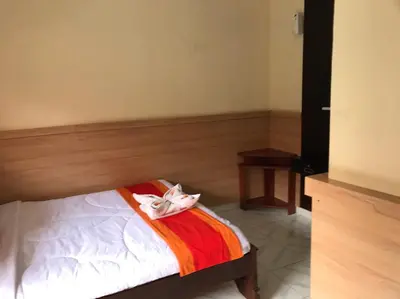 a bedroom with a bed with a mask on it at Agus Beach Inn in Kuta