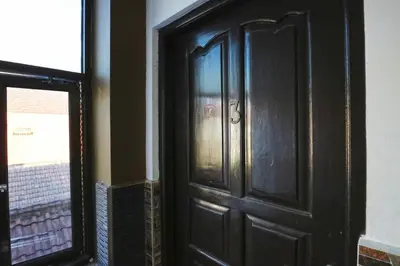 a wooden door in a room with a window at Micost Homestay in Denpasar