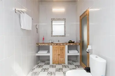 a bathroom with a sink and a toilet and a mirror at Villa Orked 1 in Seminyak