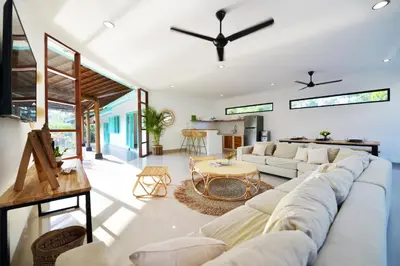 a living room with a white couch and a table at Villa Zenta in Canggu