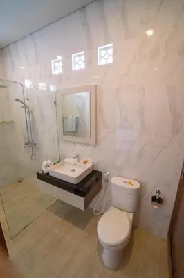 a bathroom with a toilet and a sink and a shower at Juada Garden in Seminyak