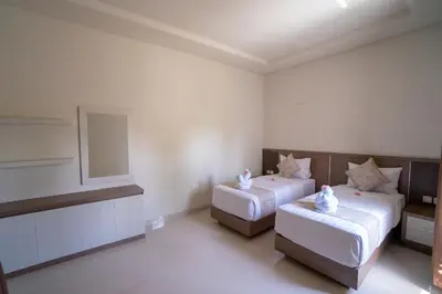 a bedroom with two beds and a mirror at Juada Garden in Seminyak