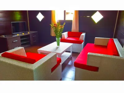 a living room with two couches and a table and a television at Juada Garden in Seminyak