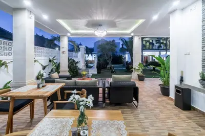 a living room with a table and chairs at Puri Uma Ratu by RPM in Seminyak