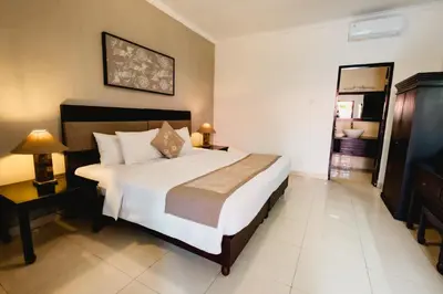 a bedroom with a large white bed in a room at Sarinande Hotel in Seminyak
