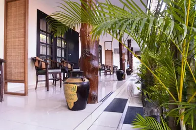 a large vase sitting in a hallway with plants at Sarinande Hotel in Seminyak