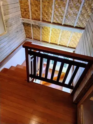 a stairway with a wooden railing in a house at Villa Made East in Seminyak
