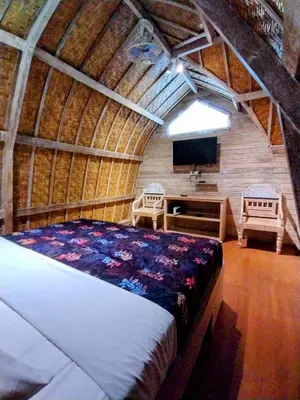 a bedroom with a bed and a flat screen tv at Villa Made East in Seminyak