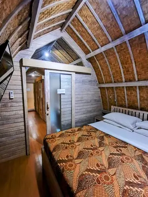 a bedroom with a large bed in an attic at Villa Made East in Seminyak