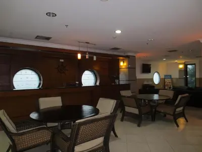 a dining room with two tables and chairs at Bali Paradise City Hotel in Denpasar