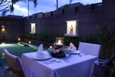 a table with a white table cloth and candles on it at Nyuh Bali Villas in Seminyak