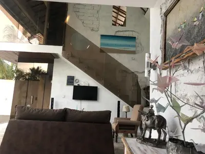 a living room with a couch and a staircase at Villa Dea in Nusa Dua