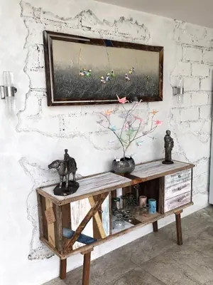 a painting hanging on a wall above a wooden table at Villa Dea in Nusa Dua
