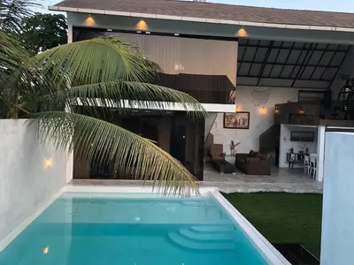 a house with a swimming pool in front of a house at Villa Dea in Nusa Dua