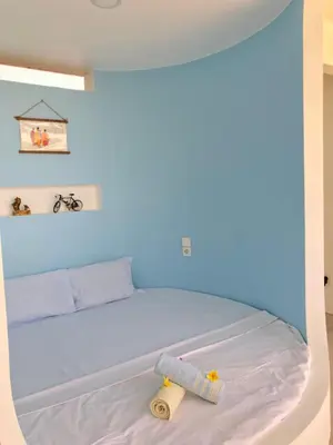 a bedroom with a bed with a blue wall at Villa Dea in Nusa Dua