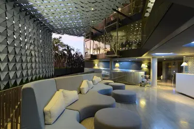 a lobby with a couch and stools in a building at IZE Seminyak by LifestyleRetreats in Seminyak
