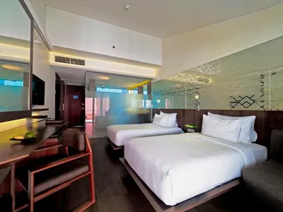 a hotel room with two beds and a desk at IZE Seminyak by LifestyleRetreats in Seminyak