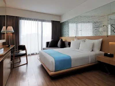 a hotel room with a large bed and a desk at IZE Seminyak by LifestyleRetreats in Seminyak