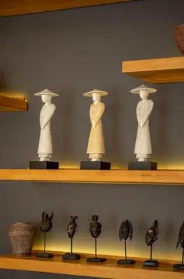 a shelf with three statues on it at Villa Artisane in Seminyak