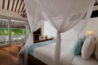 a bedroom with a white bed with a canopy at Villa Hasian Jimbaran in Jimbaran
