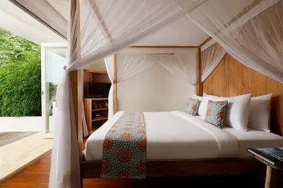 a bedroom with a bed with a canopy at Villa Hasian Jimbaran in Jimbaran
