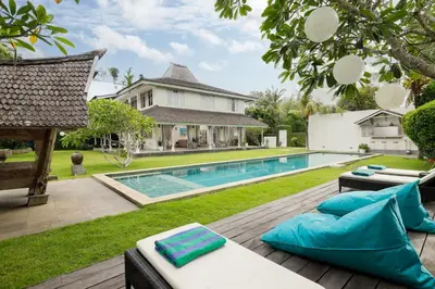 a backyard with a swimming pool and a house at Villa Hasian Jimbaran in Jimbaran