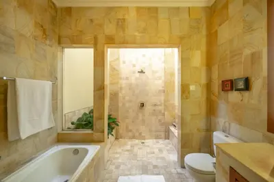 a bathroom with a tub and a toilet and a sink at Amandaru Villa by RPM in Legian