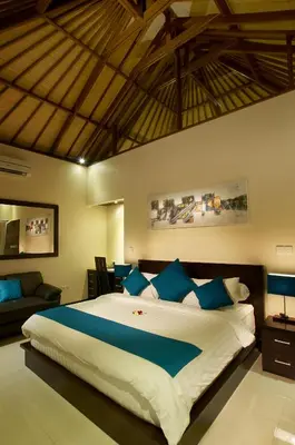 a bedroom with a large bed with blue pillows at My Villas In Bali in Seminyak