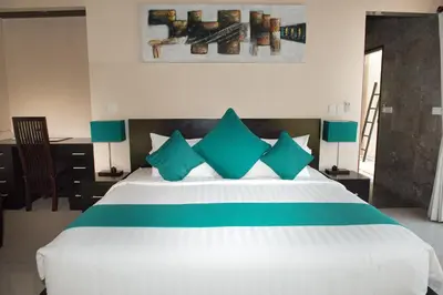 a bedroom with a large white bed with blue pillows at My Villas In Bali in Seminyak