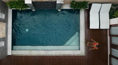 a swimming pool with a person laying in the water at My Villas In Bali in Seminyak