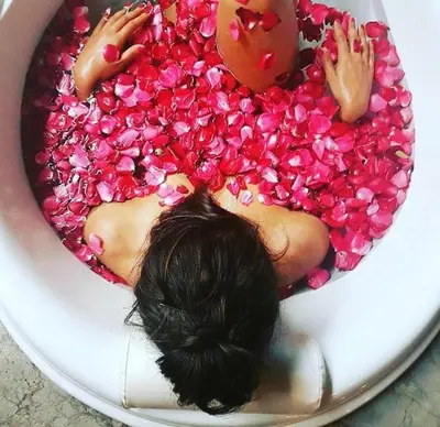 a woman laying in a bowl covered in pink sprinkles at My Villas In Bali in Seminyak