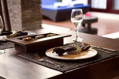 a table with a plate of food and a glass of wine at My Villas In Bali in Seminyak