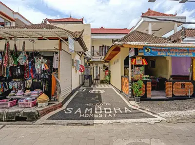 a street with two stores and a market with merchandise at Samudra Homestay in Kuta