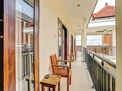 a balcony with two chairs and a table at Samudra Homestay in Kuta