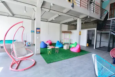 a room with colorful chairs and tables in it at Beach Hut Hostel in Kuta
