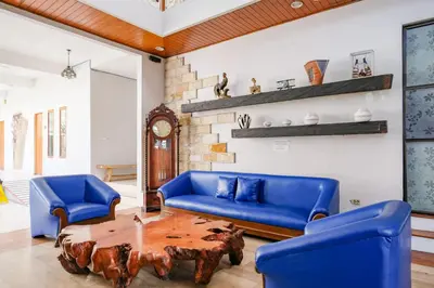 a living room with a blue couch and a wooden table at RedDoorz Plus @ Mahendradatta Denpasar in Denpasar