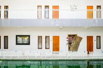 a building with a pool in front of it at RedDoorz Plus @ Mahendradatta Denpasar in Denpasar