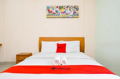 a bedroom with a bed with a red pillow on it at RedDoorz Plus @ Mahendradatta Denpasar in Denpasar