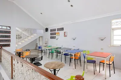 a dining room with tables and chairs and stairs at RedDoorz Plus @ Mahendradatta Denpasar in Denpasar