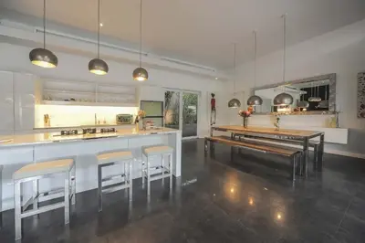 a kitchen with a counter and bar with stools at Casa Priya Petitenget in Seminyak